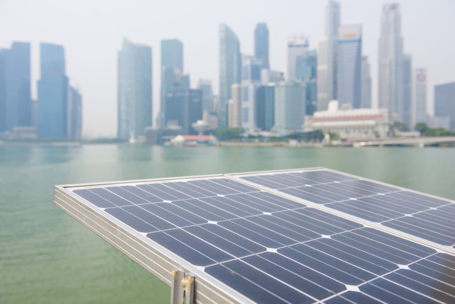 Solar panels installed with city skyline in background for renewable energy.